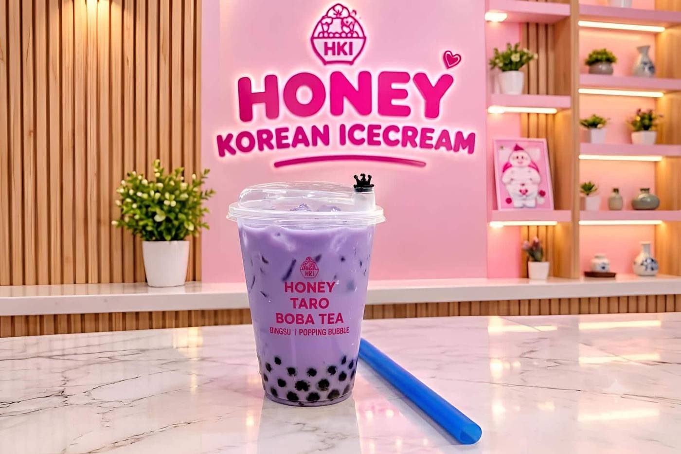 A Honey Korean Icecream taro boba tea in front of their pink HKI wall